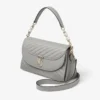 Bolso Curve Top Handle de piel Biker acolchada en color paloma con detalle de perla Bolso Curve Top Handle de piel Biker acolchada en color paloma con detalle de perla