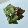 Bolso de mano Zandra de ante color trébol con pulsera de cuentas Bolso de mano Zandra de ante color trébol con pulsera de cuentas