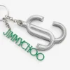 Colgante para bolso Jc Multi Charm en napa metalizada plateada y verde con el logotipo de la estrella