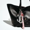 Colgante para bolso Jc Multi Charm en napa metalizada plateada y verde con el logotipo de la estrella