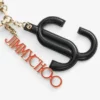 Colgante para bolso Jc Multi Charm en piel de becerro negra y naranja con logotipo de estrella