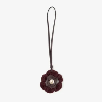 Dije de flor de punto Dije de flor de lana de punto en color merlot intenso con ribetes de cuero