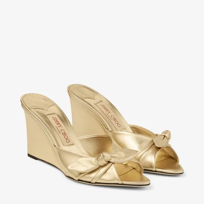 Livi Wedge 85: sandalias tipo mule de cuero napa metalizado dorado con cuña y lazo Livi Wedge 85: sandalias tipo mule de cuero napa metalizado dorado con cuña y lazo