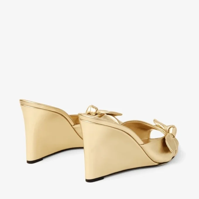 Livi Wedge 85: sandalias tipo mule de cuero napa metalizado dorado con cuña y lazo Livi Wedge 85: sandalias tipo mule de cuero napa metalizado dorado con cuña y lazo