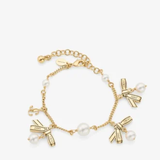 Pulsera con múltiples dijes en forma de lazo Pulsera de metal dorado con dijes, lazos y perlas Pulsera con múltiples dijes en forma de lazo Pulsera de metal dorado con dijes, lazos y perlas