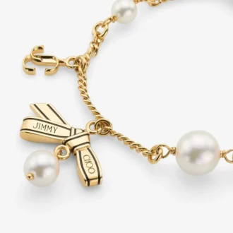 Pulsera con múltiples dijes en forma de lazo Pulsera de metal dorado con dijes, lazos y perlas Pulsera con múltiples dijes en forma de lazo Pulsera de metal dorado con dijes, lazos y perlas
