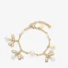 Pulsera con múltiples dijes en forma de lazo Pulsera de metal dorado con dijes, lazos y perlas Pulsera con múltiples dijes en forma de lazo Pulsera de metal dorado con dijes, lazos y perlas